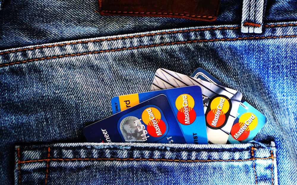 Credit cards tucked into a jeans pocket, illustrating consumer debt